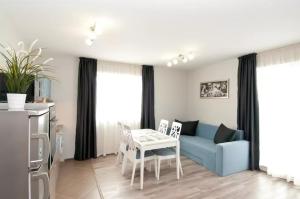 Sofia Top Lux Apartment في صوفيا: غرفة معيشة مع أريكة زرقاء وطاولة
