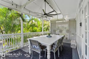 a white porch with a table and chairs on it at BELLA ABODE AND POOL 4 Bedroom Entertainer in Bongaree