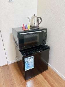 a microwave with a tea kettle on top of it at HB Home TOKYO in Tokyo