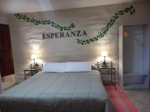 a bedroom with a bed with a sign on the wall at Hosteria Felipa Pastor - Ex Munay Humahuaca in Humahuaca