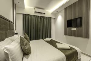 a hotel room with a bed and a television at Hotel Hycon in Kozhikode +25 photos