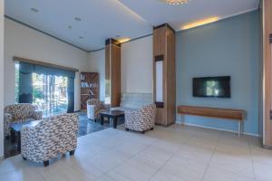 a waiting room with a desk and chairs and a tv at The Gap Hotel Kuşadası in Kuşadası