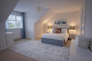 a bedroom with a white bed and a white rug at BraeView House in Inverness