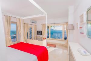 a white bedroom with a red bed and a window at La Demeure in Sidi Bou Saïd +74 photos