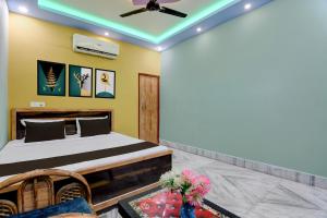 a bedroom with a bed and a ceiling fan at Hotel O by OYO AM2PM Restaurant Cum Bar in Jangipur +28 photos