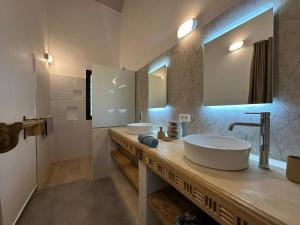 a bathroom with two sinks and a large mirror at ADWO Lodge in Ngaring +44 photos