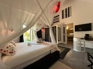 a bedroom with a large bed with white curtains at ADWO Lodge in Ngaring