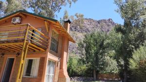 a house with a balcony and a mountain in the background at Cabaña Cerro Lindo in San Rafael +8 photos