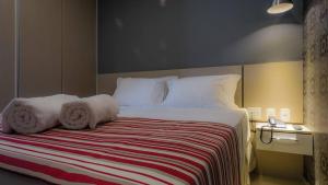 a bedroom with a bed with towels on it at Grande Hotel Ipatinga in Ipatinga