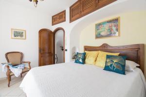 a bedroom with a large white bed with blue pillows at Anna Apartment in Positano