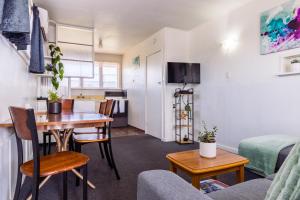 a small living room with a table and a kitchen at Belle Bonne Motel in Christchurch