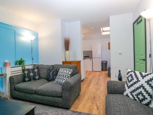 a living room with a couch and a kitchen at Havelock Hideaway in Windermere