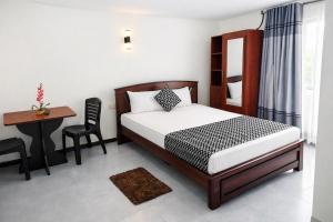 a bedroom with a bed and a table and a desk at Blue Diamond Resort in Trincomalee +53 photos
