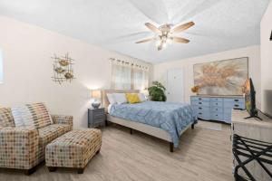 a bedroom with a bed and a couch and a ceiling fan at Rough River Lake Hideaway Your Lakeside Escape in Fentress McMahan
