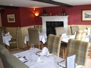 a dining room with tables and chairs and a fireplace at The Stapylton Arms in Wass