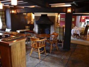 a restaurant with a fireplace and a table and chairs at The Stapylton Arms in Wass