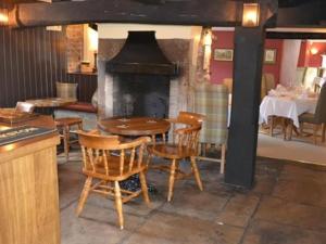 a restaurant with a table and chairs and a fireplace at The Stapylton Arms in Wass