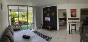 a living room with a couch and a table and a kitchen at Douceur de vivre in Sainte-Anne