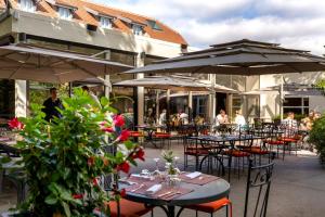 a group of tables and chairs with umbrellas at Hostellerie du Royallieu in Compiègne