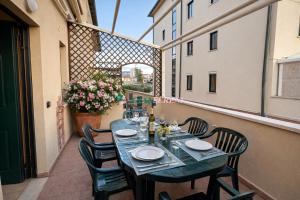 a table on the balcony of a building with chairs and a table at Palme in San Vincenzo