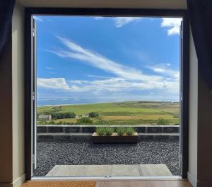 a window view of a field from a house at Lothmore Lookout - Sunset in Kilmote