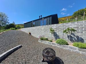 a house on a hill with a brick wall at Lothmore Lookout - Sunset in Kilmote