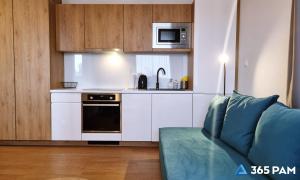 a living room with a couch and a kitchen at 365PAM - Prywatne apartamenty w hotelu in Sarbinowo