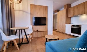 a kitchen with a table and two chairs and a tv at 365PAM - Prywatne apartamenty w hotelu in Sarbinowo