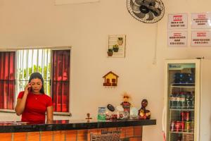 a woman standing in a kitchen talking on a cell phone at POUSADA ESTRELA DA MANHÃ in Barreirinhas +58 photos