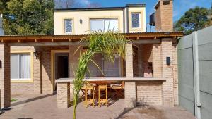 a brick house with a table and chairs on a patio at Complejo Los Tilos in Chascomús
