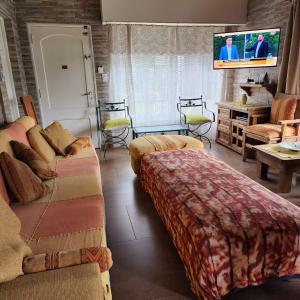 a living room with a couch and a tv at Complejo Los Tilos in Chascomús