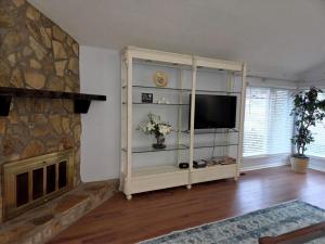 a living room with a television and a fireplace at Walk to Augusta National with Pool, Housekeeper, and Utilities Included in Augusta