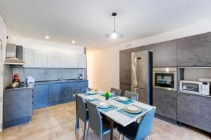 a kitchen and dining room with a table and chairs at Spacious 3BR Apartment close to Marsascala promenade in Marsaskala