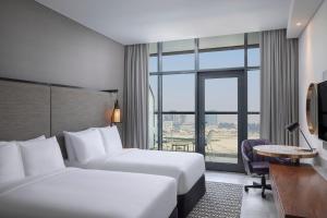 a hotel room with two beds and a window at The First Collection Waterfront, Dubai, a Tribute Portfolio Hotel in Dubai