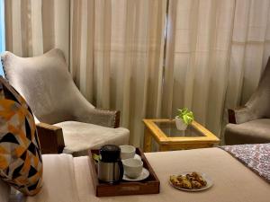 a room with a chair and a table with a tray of food at Vyom Boutique Hotel by Aramah in Rishīkesh