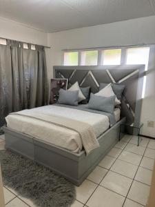 a bedroom with a large bed with a large headboard at House by balinty in Johannesburg