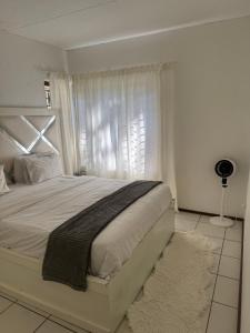 a bedroom with a bed with a window and a rug at House by balinty in Johannesburg