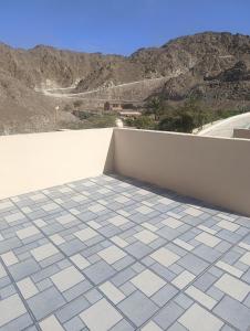 a balcony with a tile floor and a wall at Dareen Resort 1 in Bahlāʼ