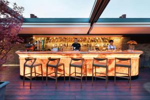 a bar with chairs and two people standing behind it at The Chesterfield Mayfair in London +125 photos