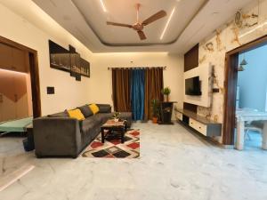 a living room with a couch and a ceiling fan at Tranquil service apartment in Chikmagalūr