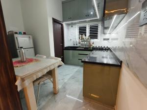 a kitchen with a table and a counter top at Tranquil service apartment in Chikmagalūr