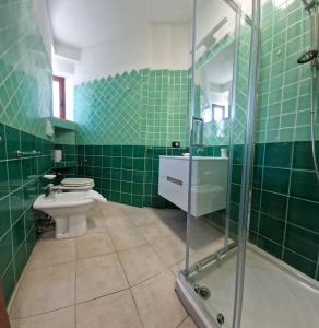 a green tiled bathroom with a toilet and a shower at Centrale! Comodo appartamento a Palau con parking! in Palau +8 photos