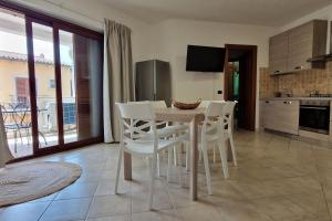 a kitchen with a table and white chairs in a room at Centrale! Comodo appartamento a Palau con parking! in Palau