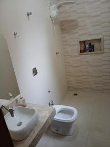 a bathroom with a white toilet and a sink at Quartos Festa do Peão Barretos in Barretos +8 photos
