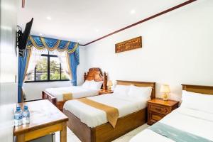 a hotel room with two beds and a window at Boeung Prolet Guest House in Kampot