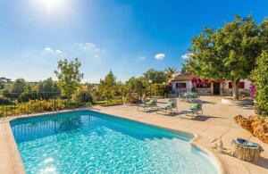 a swimming pool in a yard with chairs and trees at Ideal Property Mallorca - Ca Na Venta in Lloret de Vistalegre