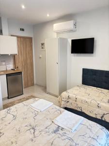a small room with two beds and a kitchen at Minas Luxury Studios in Stavros
