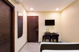 a room with a bed and a table with a television at Hotel O Premium 12th Night in kolkata