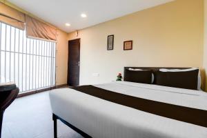 a large bed in a room with a large window at Hotel O Premium 12th Night in kolkata