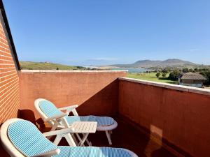 a balcony with two chairs and a view of the ocean at Dúplex Mies de Usgo in Miengo